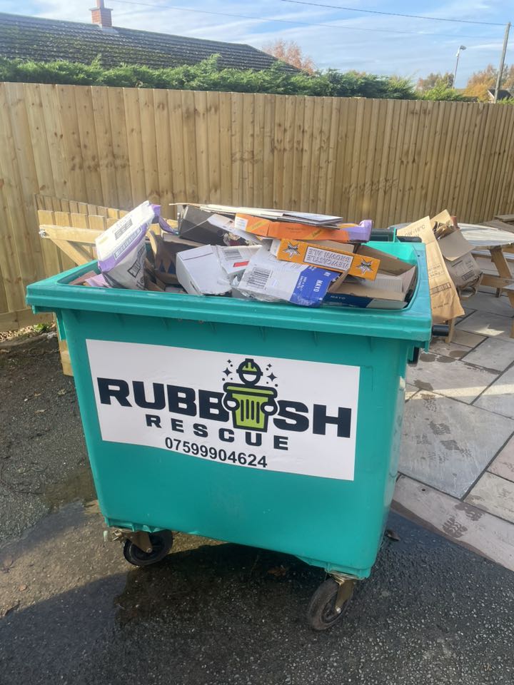 A filled large waste bin with the Rubbish Rescue logo on