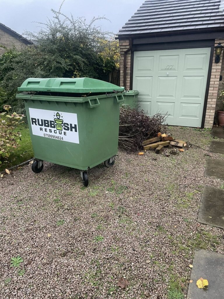 A large waste bin in a driveway with the Rubbish Rescue logo on